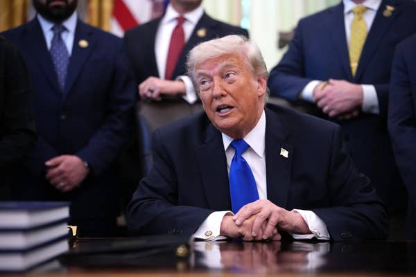 donald trump speaking at desk blue tie