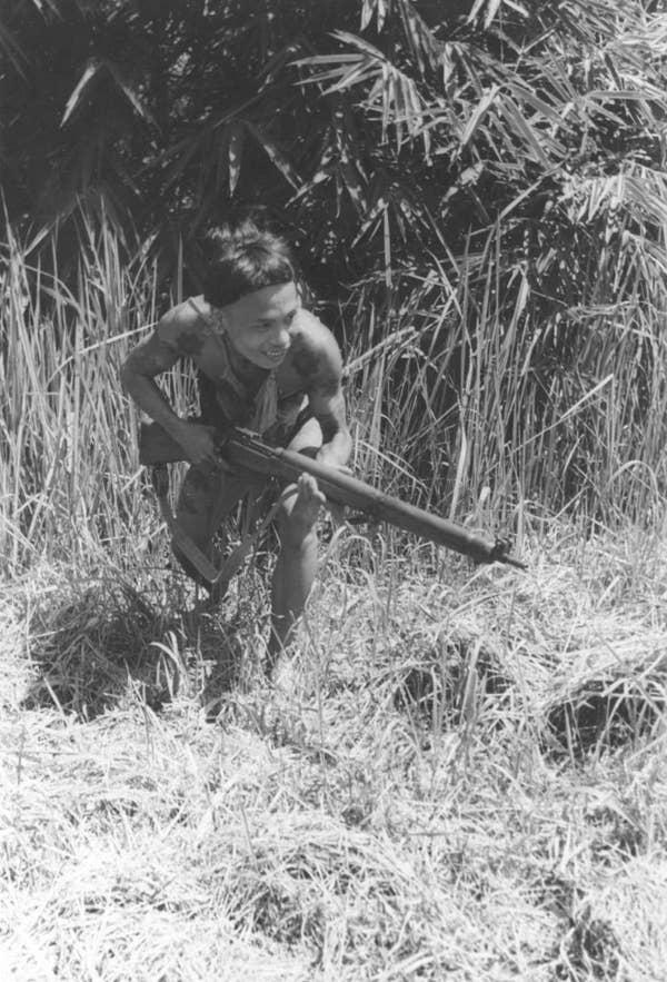 ibans warrior with rifle crouching in jungle