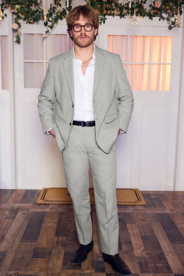 man in light grey suit with tortoise glasses