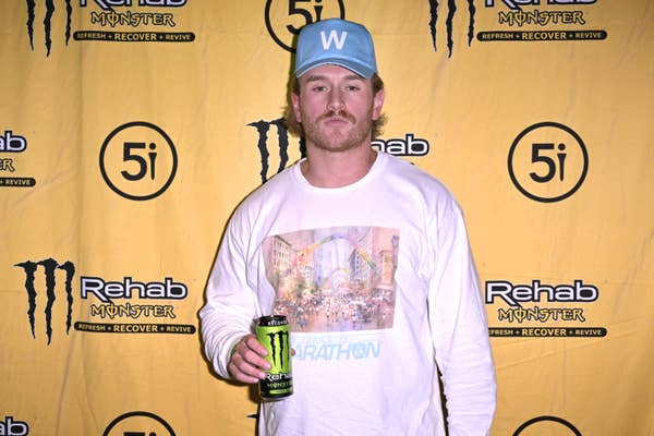 man in white graphic long sleeve and blue hat