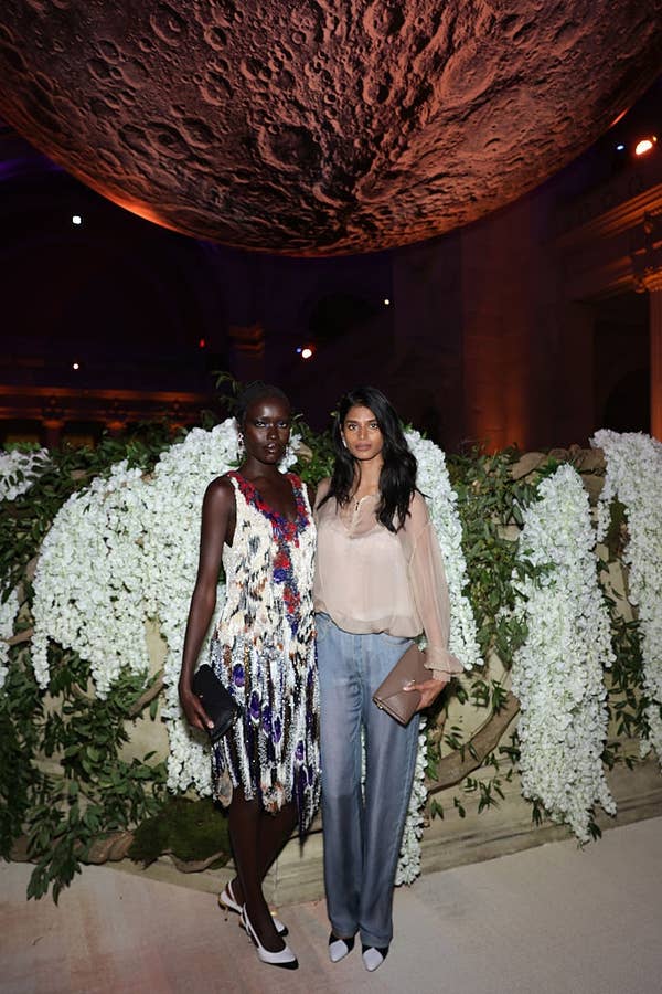 models posing under moon installation met gala