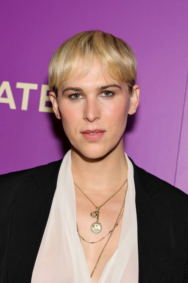 woman blonde pixie cut gold jewelry purple background.jpg