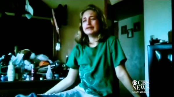 young woman crying green shirt bedroom